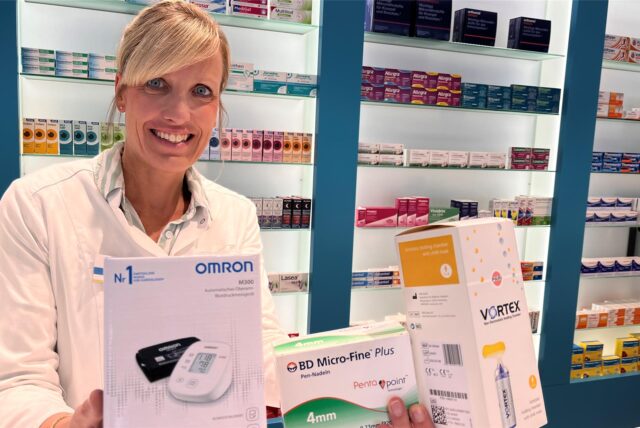 Die Kamener Apothekerin Verena Löcken steht in ihrer Apotheke. Sie hält unter anderem ein Blutdruckmessgerät und Nadeln in die Kamera.