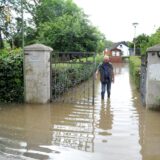 Ein Mann steht knöchelhoch im Hochwasser am Eingang der Kleingartenanlage „Amsel“.