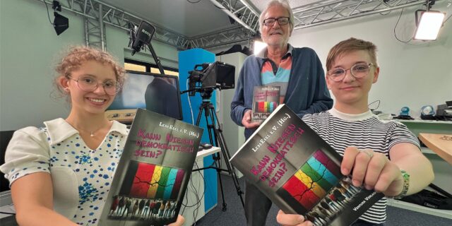 „Kann Niesen demokratisch sein?“ So lautet der Titel der Anthologie, in der auch Beiträge von Hannah Balmaceda (16), Willi Schnieder und Jule Scherbes (15) vertreten sind. Die Drei stehen im Studio des Hellweger Anzeigers an der Wasserstraße in Unna.