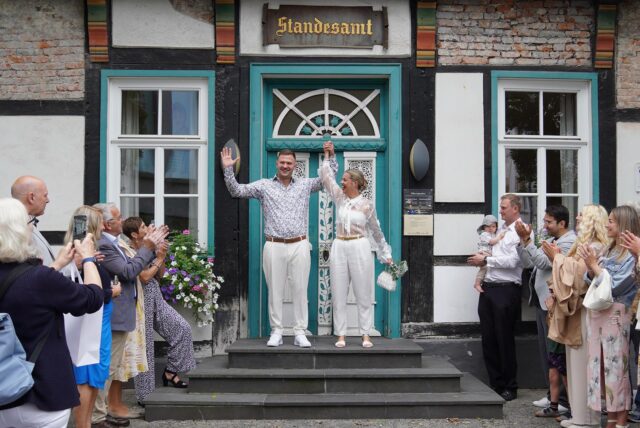 Svea und Justin stehen vor dem Standesamt in Unna und jubeln.