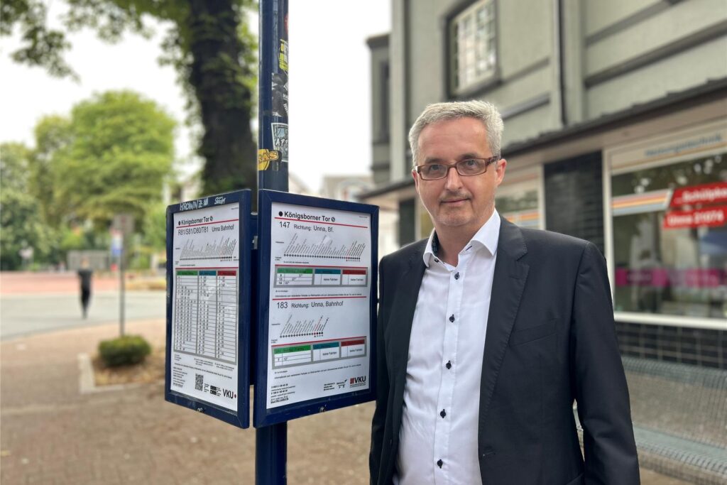 Ein Mann steht neben einem Busfahrplan am Königsborner Tor. Der Fahrplan zeigt die Abfahrtszeiten der Linien 147 und 183 an. Ein Mann steht neben einem Busfahrplan am Königsborner Tor. Der Fahrplan zeigt die Abfahrtszeiten der Linien 147 und 183 an.