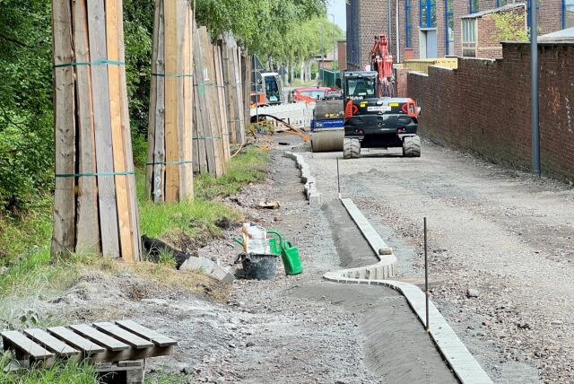 Die Saarbrücker Straße wird in einen Radweg umgebaut. Auf der Trasse rollt ein Bagger, links im Bild ist zu erkennen, wie die Stämme der Alleenbäume zum Schutz mit Holzlatten eingepackt sind.