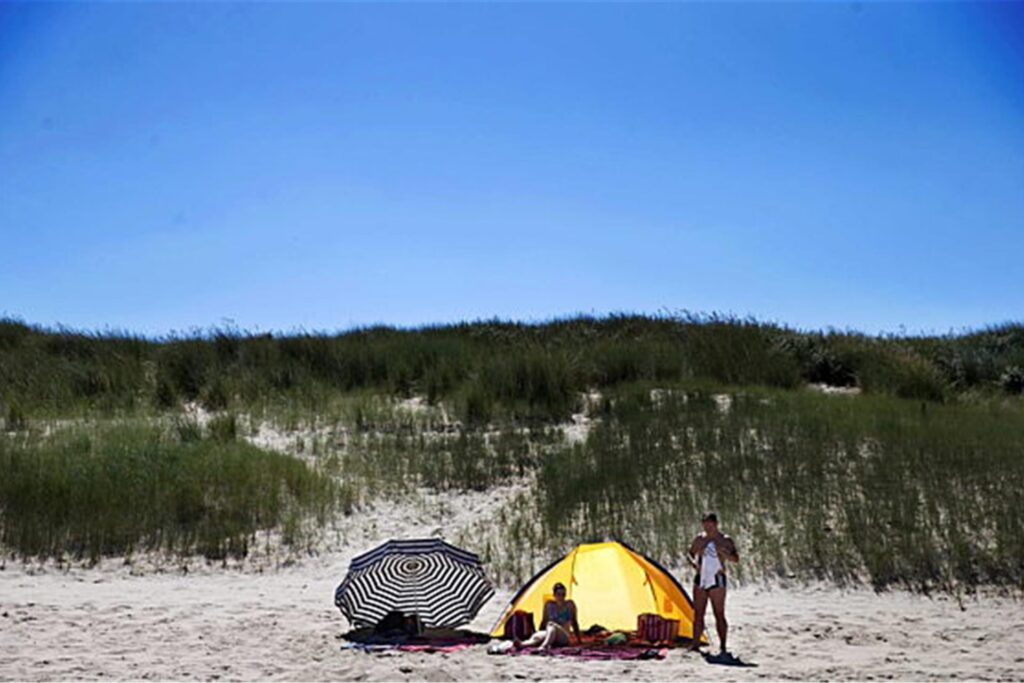 Ein Pärchen sitzt in einer Strandmuschel am Strand von Cadzand. Ein Pärchen sitzt in einer Strandmuschel am Strand von Cadzand.