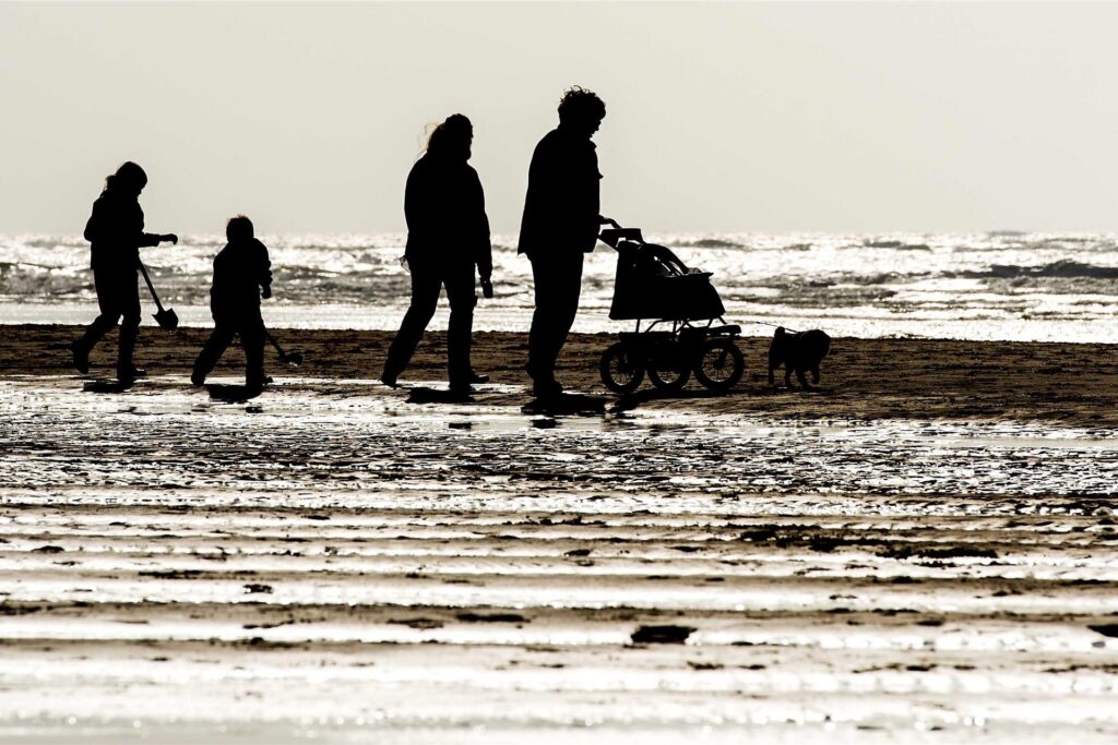 Eine Familie geht am Strand von Egmond aan Zee. Eine Familie geht am Strand von Egmond aan Zee.