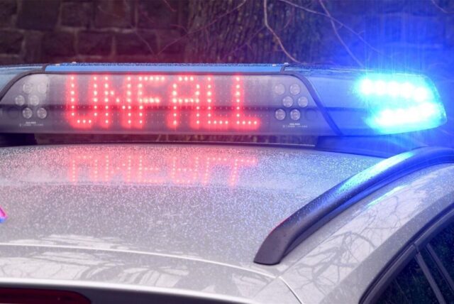 Blaulicht auf einem Polizeiauto mit dem Schriftzug ‚UNFALL‘ in roter LED-Anzeige