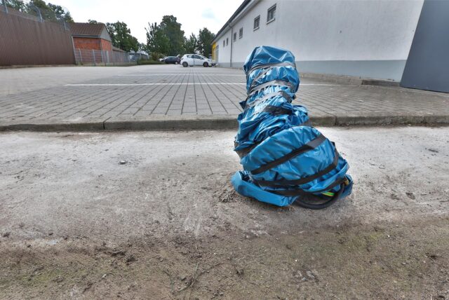 Ein blauer Sack verhüllt die Technische Anbindung an der Stelle, wo bis vor kurzem noch eine Packstation von DHL war.