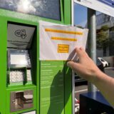 Ein weißes Blatt Papier mit der Aufschrift: „Heute ist leider keine Bargeldzahlung möglich! Nur EC-Karte und Easy Park App. Wir akzeptieren nur Kartenzahlung“. Im Hintergrund sieht man eine Parkfläche mit einzelnen Fahrzeugen.