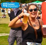 Eine junge Frau hält beim Juicy Beats Festival in Dortmund ein Bier und ein Mixgetränk in die Höhe. Getränke und Speisen können 2025 nur mit Bargeld gezahlt werden.