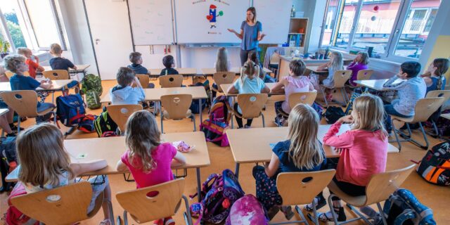 Schülerinnen und Schüler einer dritte Klasse sitzen während des Unterrichts in ihrem Klassenzimmer.