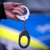 Handschellen vor Polizeiwagen
