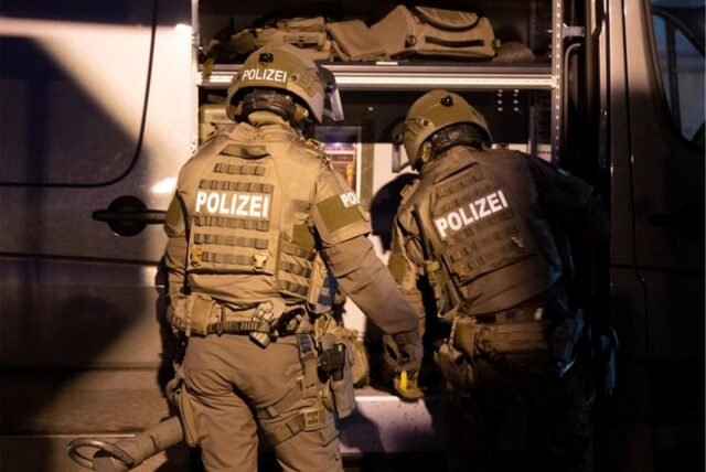 Beamte eines Spezialeinsatzkommandos (SEK) der Polizei agieren in einem Wohngebiet.
