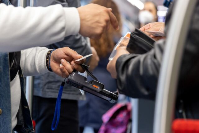 Ein Fahrkartenkontrolleur kontrolliert einen Fahrgast. Nahaufnahme.