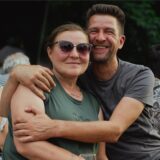 Besuchende des Sommer-Pop-Konzerts 2025 im Sesekepark in Kamen. Ein Mann umarmt eine Frau. Beide schauen in die Kamera, im Hintergrund sind viele andere Menschen.