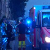 Polizisten stehen bei einem Einsatz vor einem Rettungswagen mit Blaulicht.