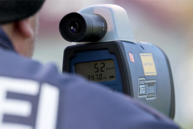 Polizeibeamter mit Laser-Messgerät.