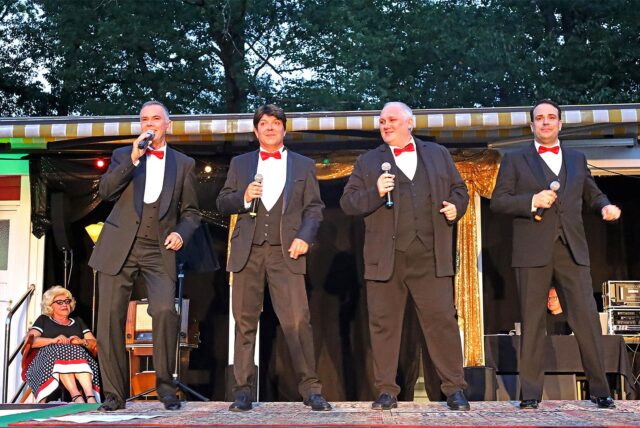 Vier Mitglieder der Band „Bühnenreif“ stehen im Elsebad in Schwerte-Ergste auf der Bühne. Sie tragen Anzüge mit roten Fliegen und singen in Mikrofone.