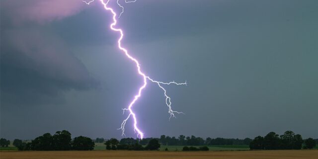 Ein Blitz über einem Feld (Symbolbild)