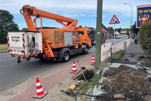 Ein Hubsteiger steht vor der defekten Straßenlaterne. Der Boden ist ausgeschachtet, um den Mast zu erneuern.