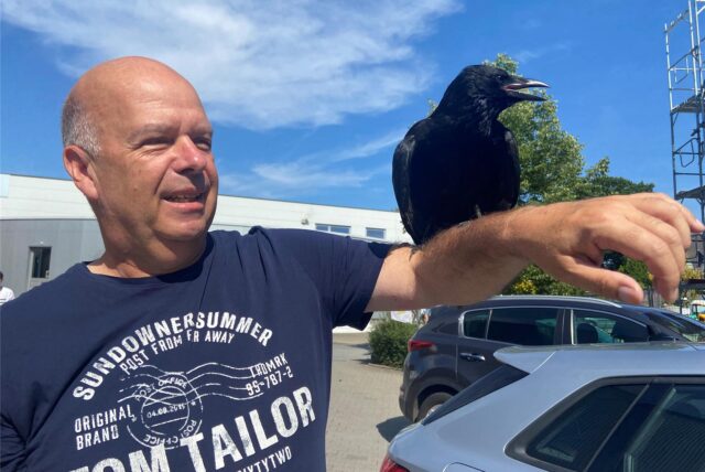 Carsten Engelkind mit einem Rabenvogel auf dem Arm.