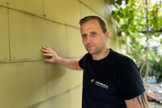 Der Schadstoffsanierer Dennis Burmann aus Dortmund-Barop wirft hier einen ersten Blick auf eine Fassade mit Asbestzement-Platten. Asbest wurde bis in die 1980er-Jahre vielfach verbaut.