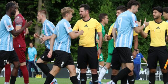 Spieler und Schiedsrichter klatschen sich ab.