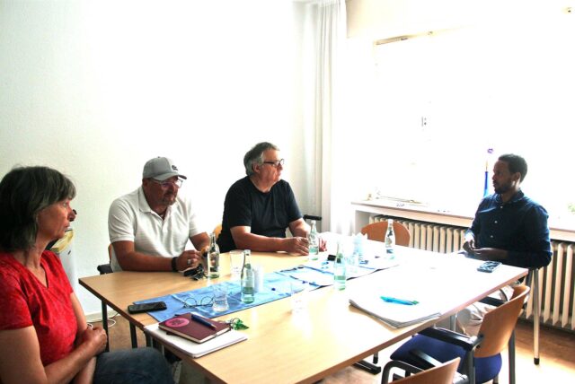 Vier Personen sitzen um einen Tisch.