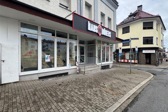 Das Foto zeigt die Fassade eines Geschäftsgebäudes an der Schäferstraße 16 in Unna nahe der Innenstadt. Die Aufschrift „Haus des Döners“ ist über dem Eingangsbereich zu sehen, während der alte Name des Geschäfts „Ali’s Döner & Pizzahaus“ noch an manchen Stellen im Schaufenster zu entziffern ist.