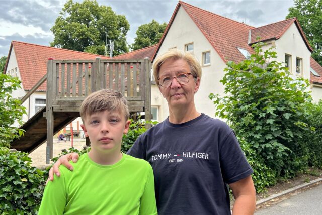 Ben und seine Mutter Anja Böhle stehen vor der seiner ehemaligen Grundschule in Hemmerde
