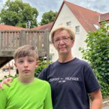 Ben und seine Mutter Anja Böhle stehen vor der seiner ehemaligen Grundschule in Hemmerde
