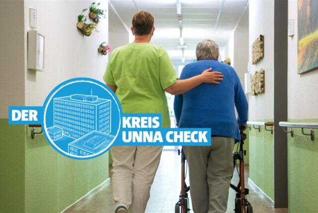 Eine Pflegerin und eine Pflegperson gehen gemeinsam über den Gang eines Pflegeheims.