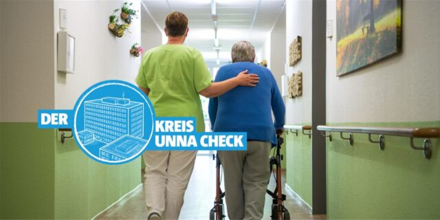 Eine Pflegerin und eine Pflegperson gehen gemeinsam über den Gang eines Pflegeheims.