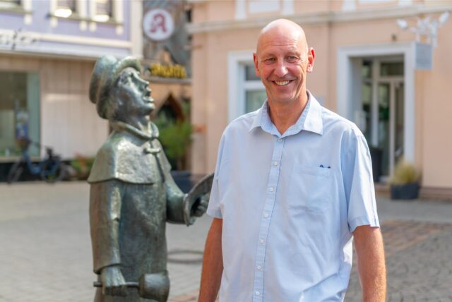 Volker Abdinghoff auf dem Werner Marktplatz vor einer Bronzestatue