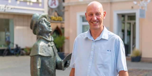 Volker Abdinghoff auf dem Werner Marktplatz vor einer Bronzestatue