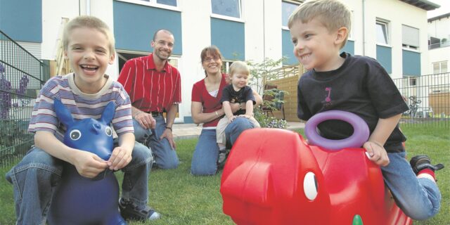 Ein Ehepaar lässt seine drei Kinder im Garten eines noch neuen Reihenhauses in Königsborn spielen.