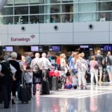 Reisende stehen mit ihrem Gepäck an den Check-In-Schaltern am Düsseldorfer Flughafen. Die Bezirksregierungen in Nordrhein-Westfalen haben im vergangenen Jahr insgesamt 9.034 Bußgeldverfahren wegen Verletzung der Schulpflicht eingeleitet.