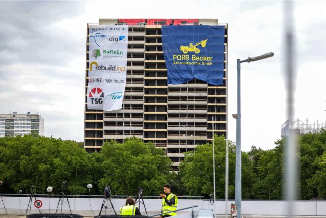 Werbebanner der an der Sprengung beteiligten Unternehmen hängen am „Weißen Riesen“.
